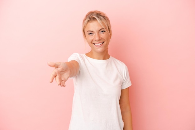 Young Russian woman isolated on pink background smiling and raising thumb up