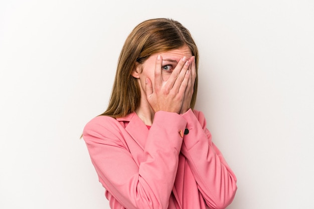 Young russian woman isolated on white background blink through fingers frightened and nervous