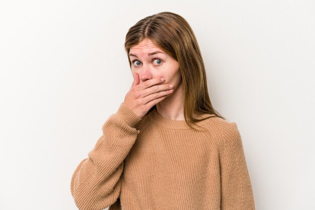 Young russian woman isolated on white background covering mouth with hands looking worried