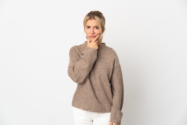 Young Russian woman isolated on white background having doubts