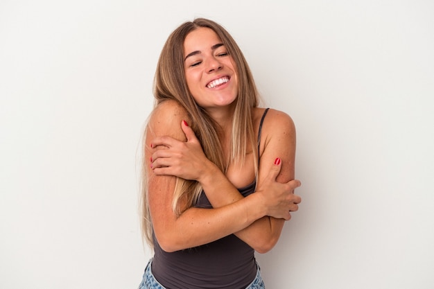 Young Russian woman isolated on white background hugs, smiling carefree and happy.