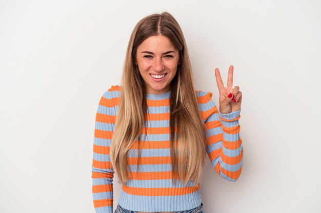 Young Russian woman isolated on white background joyful and carefree showing a peace symbol with fingers.