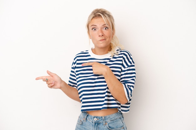 Young Russian woman isolated on white background shocked pointing with index fingers to a copy space.