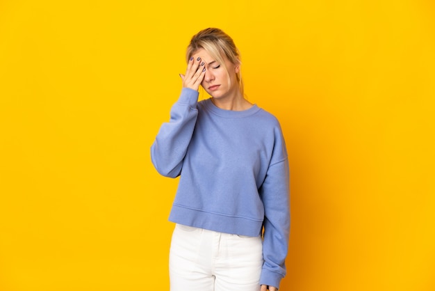 Young Russian woman isolated on yellow with headache