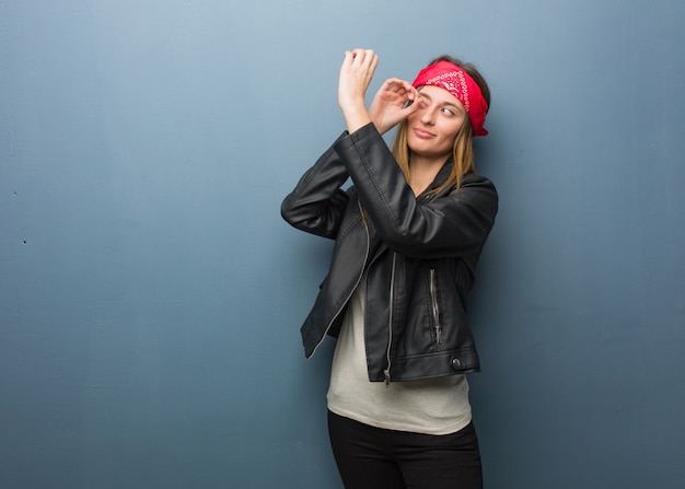 Young russian woman making the gesture of a spyglass