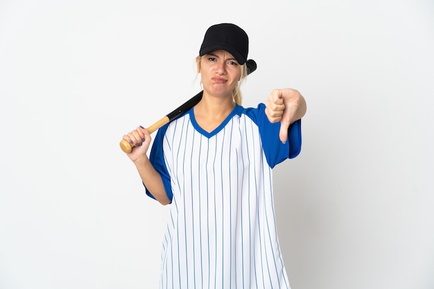 Young Russian woman playing baseball isolated on white background showing thumb down with negative expression