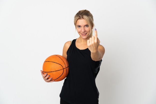 Young Russian woman playing basketball isolated on white background doing coming gesture