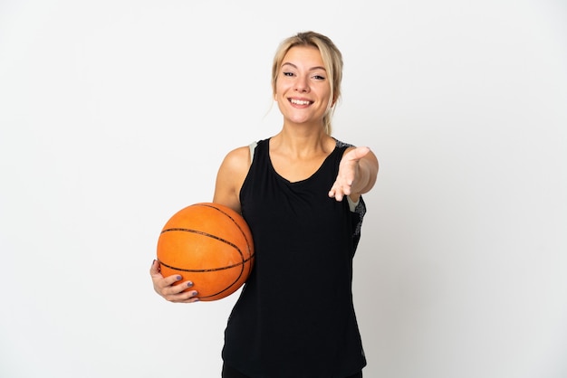 Young Russian woman playing basketball isolated on white background shaking hands for closing a good deal