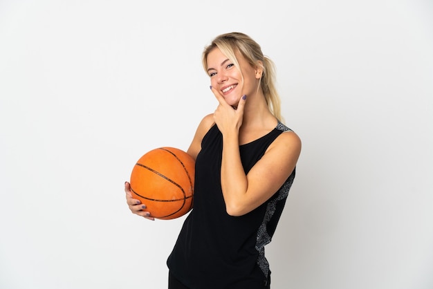 Young Russian woman playing basketball isolated on white wall happy and smiling