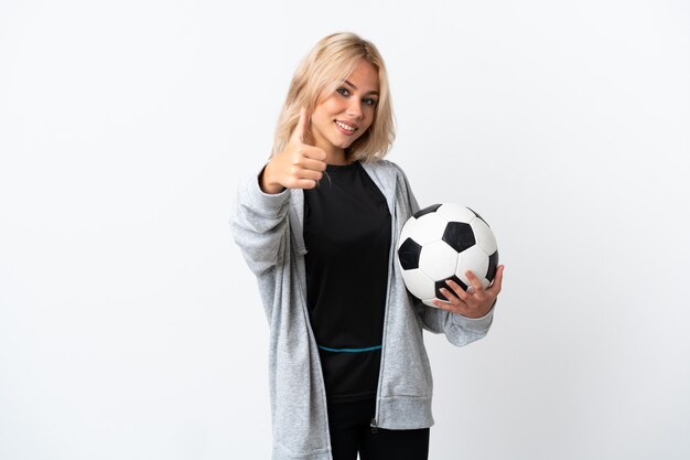 좋은 일이 일어났기 때문에 엄지 손가락으로 흰 벽에 고립 된 축구를하는 젊은 러시아 여자