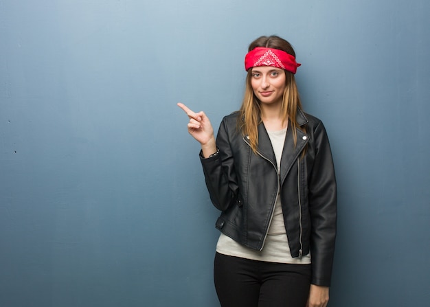 Young russian woman smiling and pointing to the side