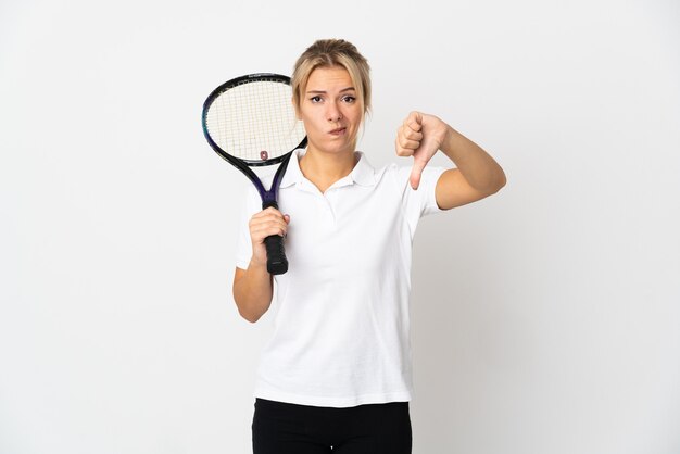 Young Russian woman tennis player isolated on white wall showing thumb down with negative expression