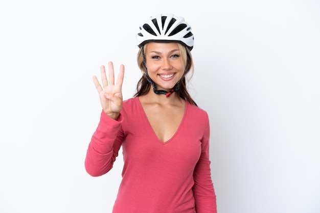 Photo young russian woman wearing a bike helmet isolated on white background happy and counting four with fingers