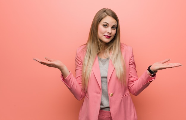 Young russian woman wearing pajama doubting and shrugging shoulders