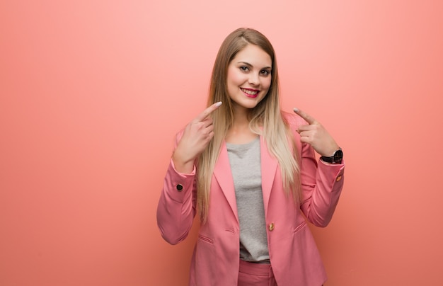 Young russian woman wearing pajama smiles, pointing mouth