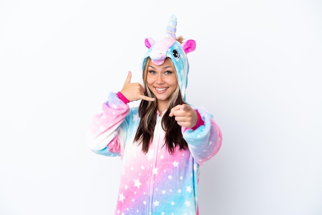 Young Russian woman wearing a unicorn pajama isolated on white background making phone gesture and pointing front