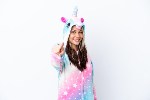 Young Russian woman wearing a unicorn pajama isolated on white background points finger at you with a confident expression