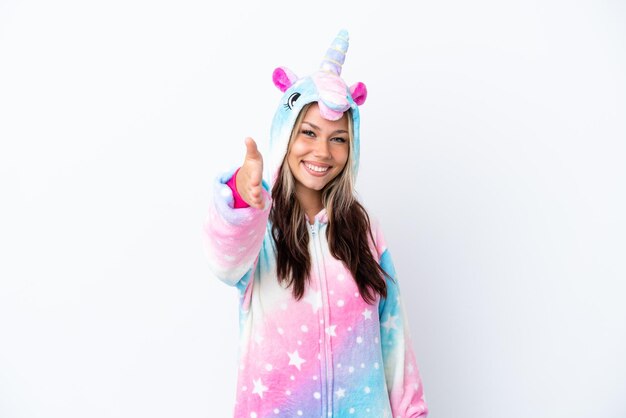 Young Russian woman wearing a unicorn pajama isolated on white background shaking hands for closing a good deal