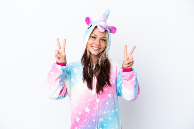 Young Russian woman wearing a unicorn pajama isolated on white background showing victory sign with both hands