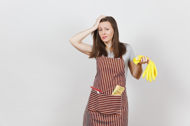 Young sad upset tired housewife in striped apron with cleaning rag in pocket isolated