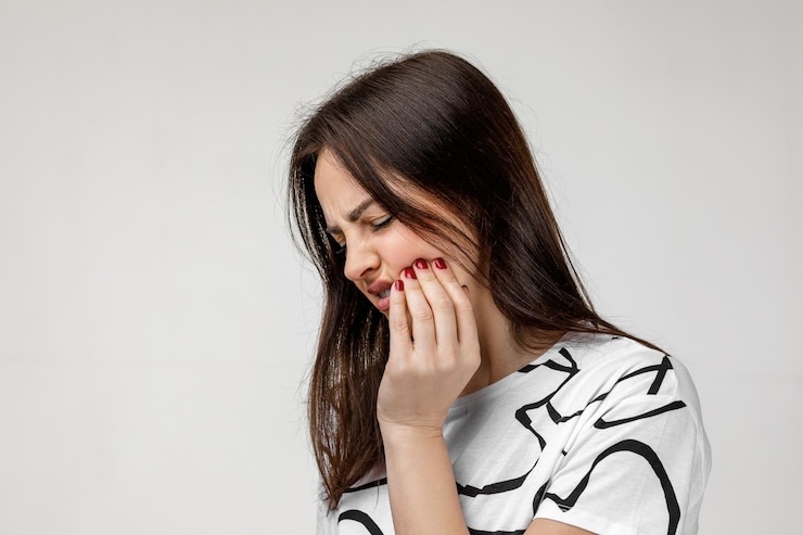 Young sad woman suffering from tooth pain
