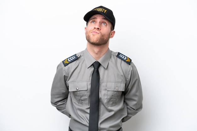 Young safeguard caucasian man isolated on white background and looking up