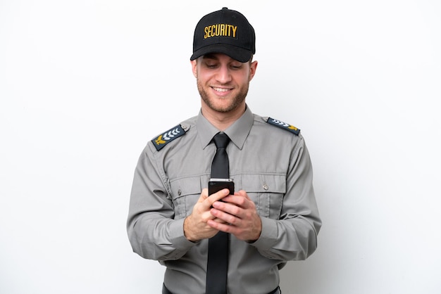 Young safeguard caucasian man isolated on white background sending a message with the mobile