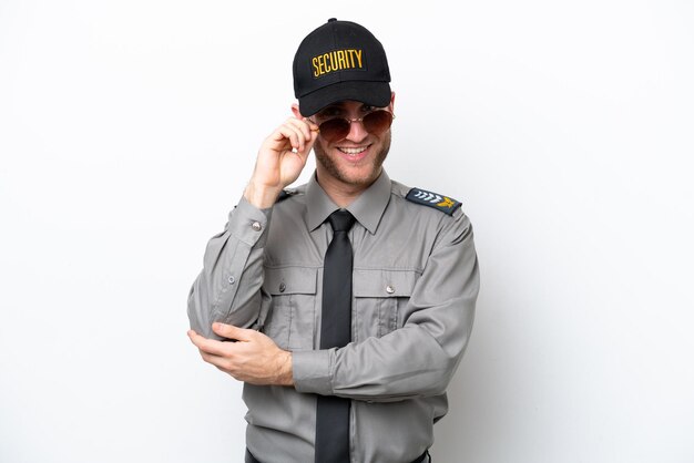 Young safeguard caucasian man isolated on white background with glasses and happy