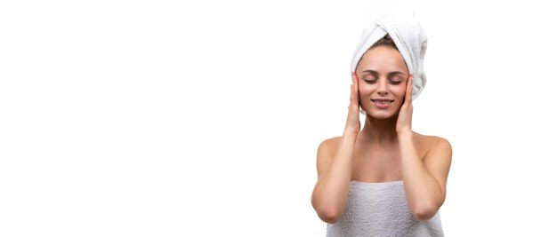 Молодая довольная женщина после спа-процедур трогает лицо руками, концепция омоложения кожи