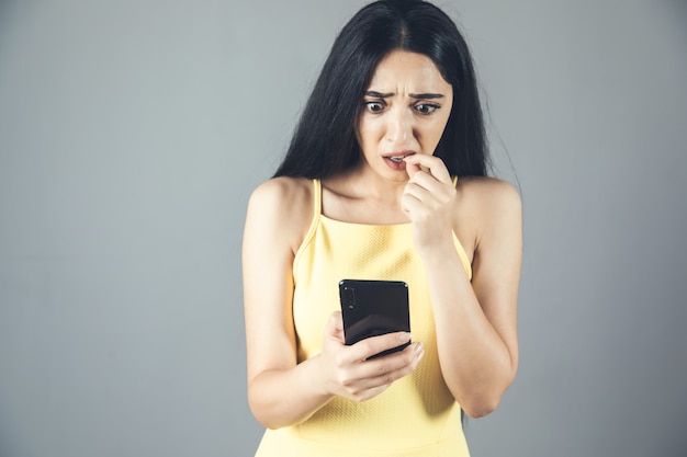 The young scared woman holding smartphone