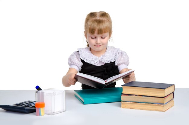 Young schoolgirl in uniform read a book isolated on white background