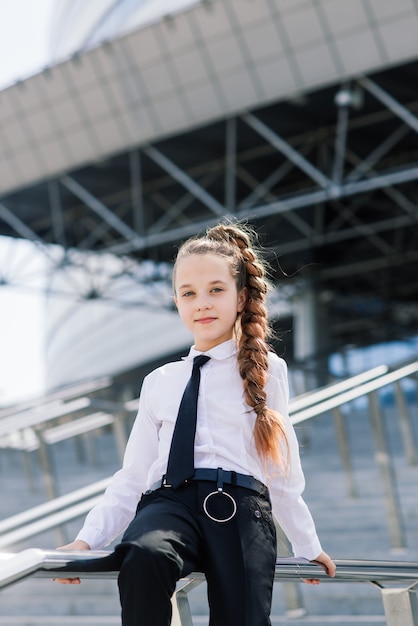 街でポーズをとる白い古典的なブラウスの若い女子高生