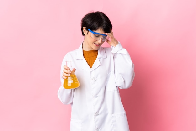 Young scientific woman isolated on pink space laughing