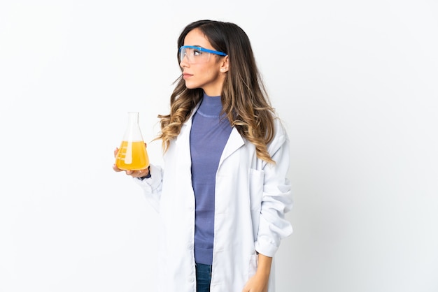 Young scientific woman isolated on white background looking to the side