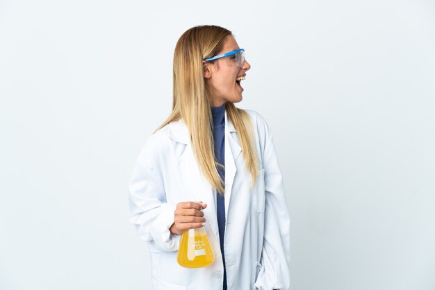 Young scientific woman isolated on white laughing in lateral position