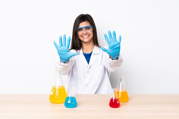 Young scientific woman in a table counting ten with fingers