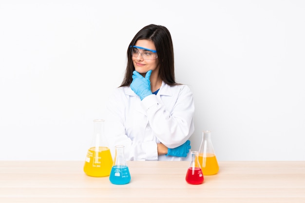 Молодая научная женщина в таблице, глядя в сторону