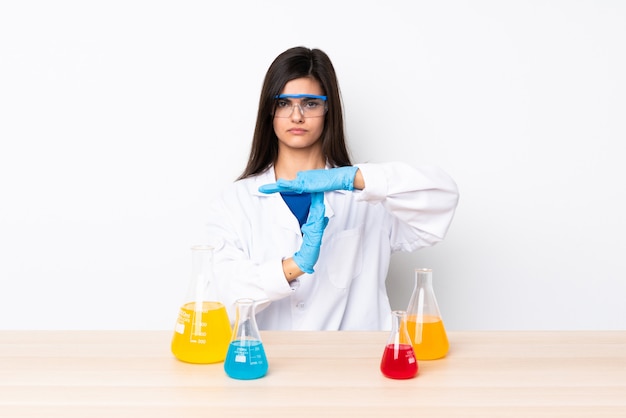Young scientific woman in a table making time out gesture