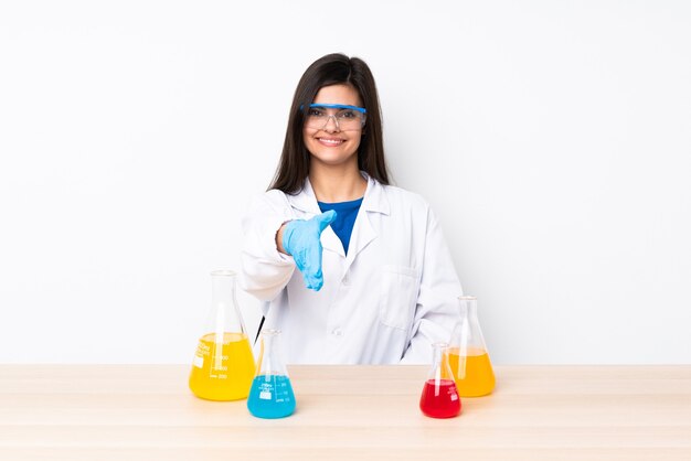 Young scientific woman in a table shaking hands for closing a good deal