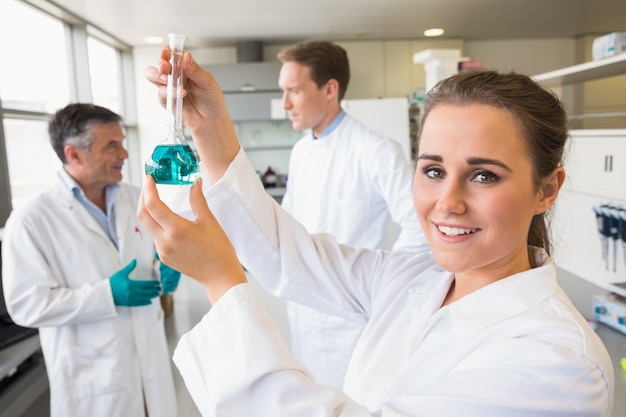 Young scientist holding up beaker