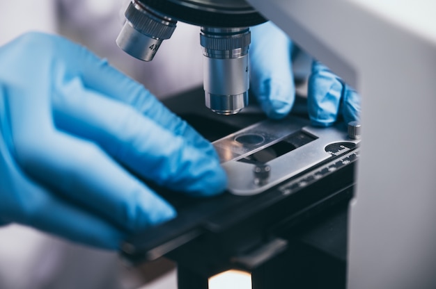 Young scientist looking through a microscope in a laboratory. Young scientist doing some research.