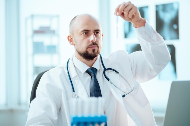 Young scientist looks at an ampoule with a vaccine. science and healthcare.