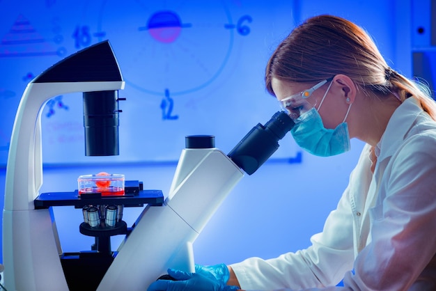 Young scientist using microscope in laboratory