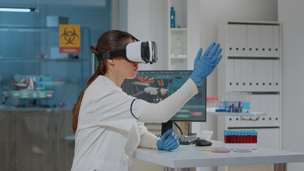 Foto giovane scienziato che indossa un simulatore di realtà virtuale in laboratorio