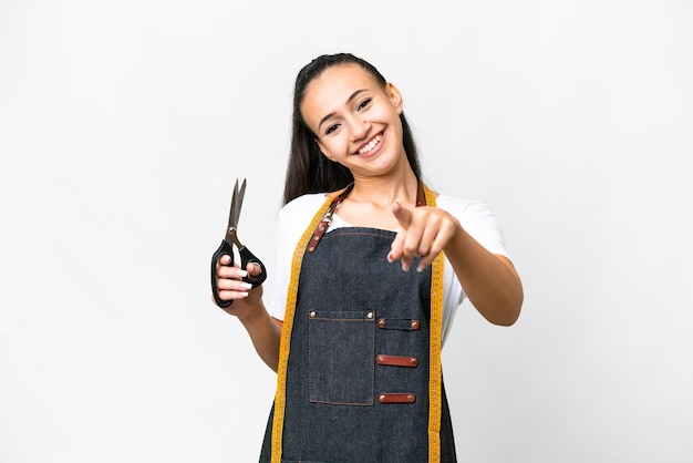 Young Seamstress woman over isolated white background pointing front with happy expression