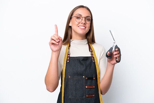 Young seamstress woman isolated on white background pointing up a great idea