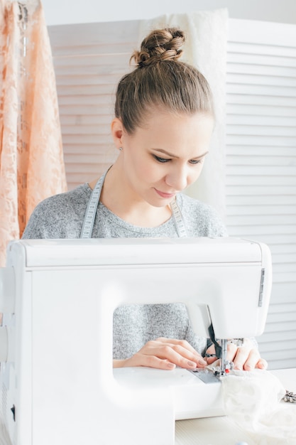 Young seamstress working on sewing machine