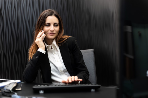 Photo young secretary on the phone in her office