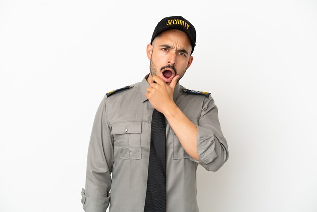 Young security  caucasian man isolated on white background surprised and shocked while looking right