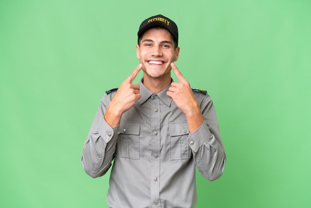 Young security man over isolated background smiling with a happy and pleasant expression